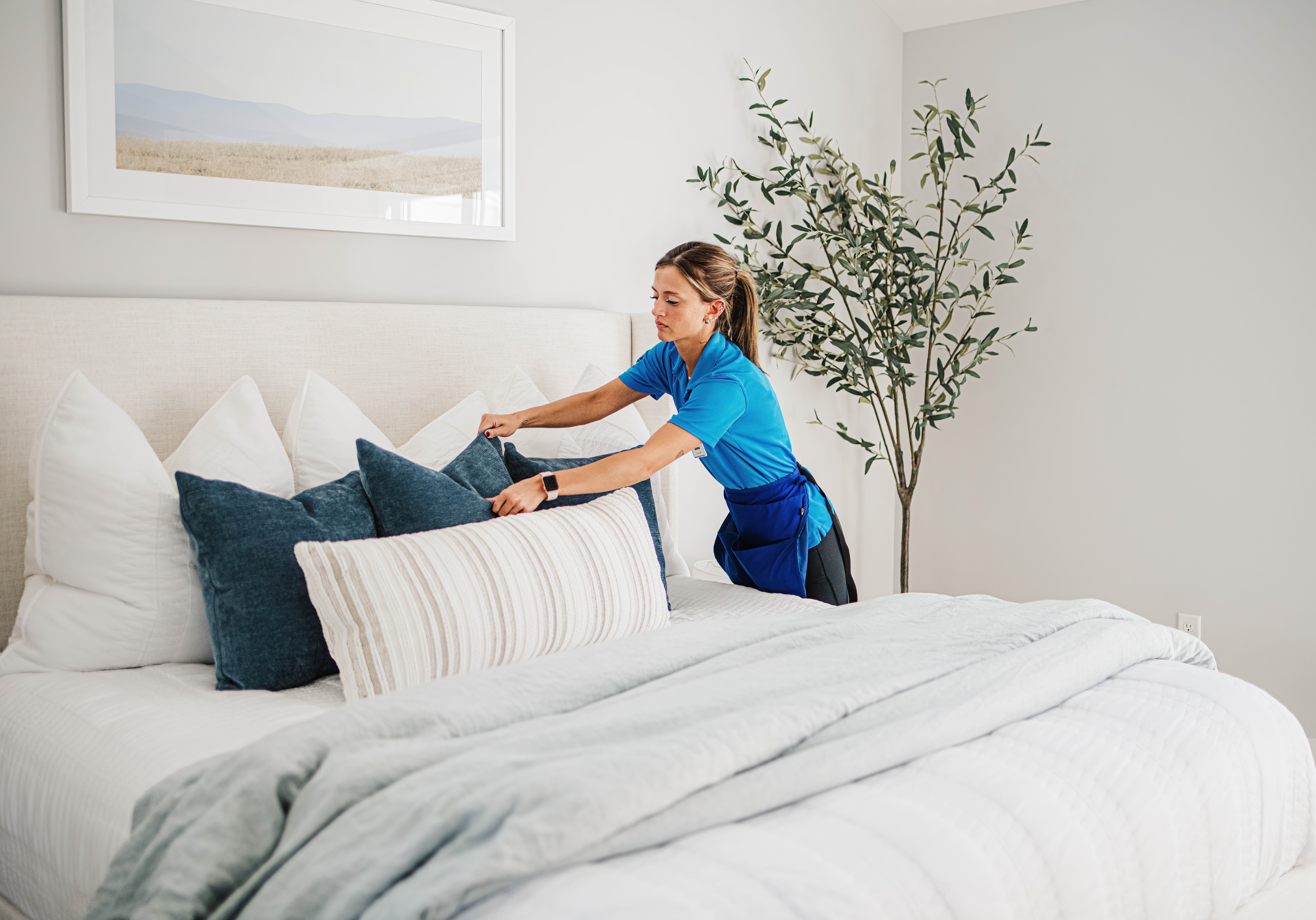 A Best Day Housecleaning cleaner making a bed during a cleaning visit.